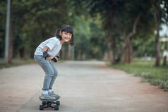 可爱的小女孩在滑板公园里玩滑板或冲浪