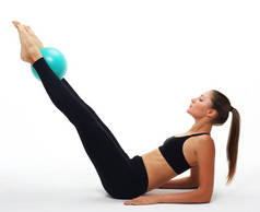 年轻健康的成年女子用体操球进行瑜伽锻炼.