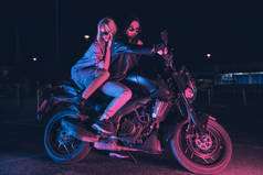 在夜晚空旷的停车场里，几个骑摩托车的女孩在霓虹灯的照耀下坠入爱河