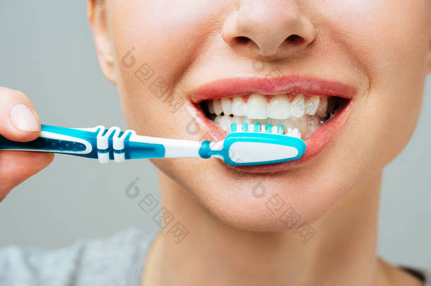 拥有<strong>健康</strong>的白牙的女人拿着牙刷笑着。<strong>口腔</strong>卫生概念