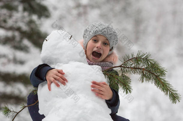 冬天，雪地公园里的小女孩和雪人.