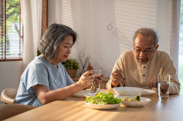 心烦意乱的亚洲老年人退休了，祖父母呆<strong>在家里</strong>，痛苦的脸坐<strong>在家里</strong>的饭桌上。感到沮丧、成熟的老年男女<strong>夫妇在家里</strong>感到不快乐、孤独和失踪.