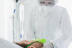 个人防护设备医生在医院检查戴氧气面罩的病人