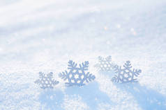 轻柔的圣诞背景。装饰雪片在大雪中在阳光照射下在大自然上，复制空间.