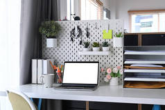 家庭写字台，配有手提电脑、用品和家居用品.