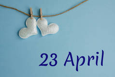 纪念日4月23日蓝色背景与白色心脏与衣针，平铺。假日日历概念世界图书和版权日