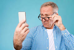 成熟的男人用手机斜视着屏幕