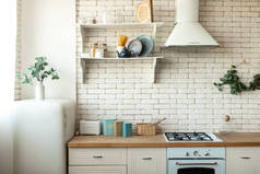 现代斯堪的纳维亚厨房内饰轻便家具,家居用品靠近砖墙.家庭装修概念