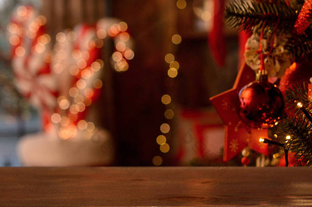 Christmas background. Empty wooden table on background of Christmas tree, fireplace, santa socks, bi