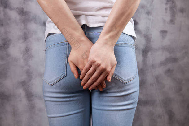 woman holding ass. hemorrhoids concept