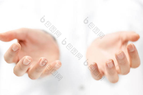 Open empty hands of young woman in white coat isolated. Caregiving and assistance concept