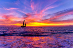 一艘船在海面上航行，夕阳西下，五彩缤纷
