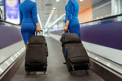 机场携带旅行行李箱的女乘务员