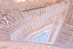 雪覆在滑溜的楼梯上，抽象的冬季背景构图Icy和雪地的楼梯通向了望塔的顶部