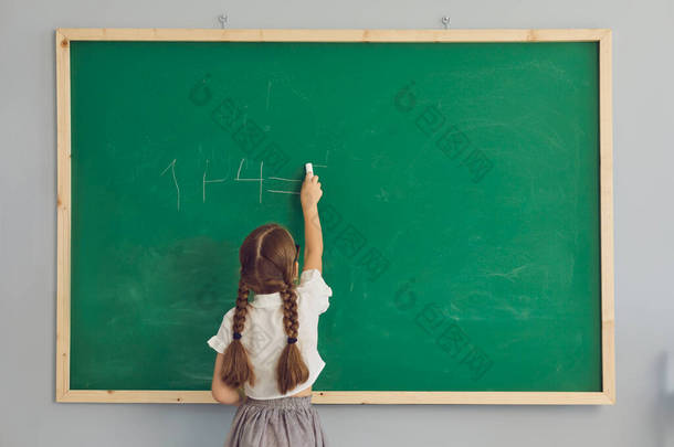 女生写下算术和绿色学校黑板的背景图
