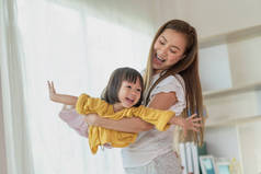 妈妈在家里和女儿玩得很开心，快乐的亚洲小孩，家庭观念