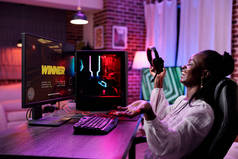 女性esport玩家在pc上玩在线视频游戏，用霓虹灯在原处玩动作游戏锦标赛。玩流媒体游戏的女玩家.