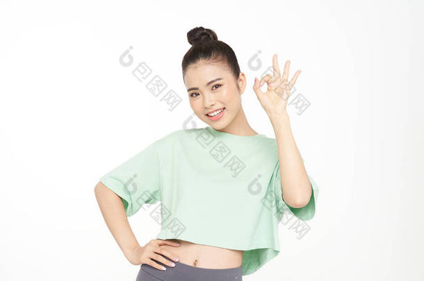 亚洲漂亮的年轻女子，手握手势，面容俊俏，<strong>身穿运动服</strong>，与白色背景隔离