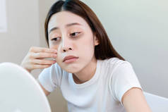 亚洲年轻女性压力镜检查因熬夜昏昏欲睡，脸上有黑眼圈。努力工作，没有时间睡觉.
