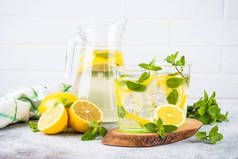 柠檬水在白桌边的两杯玻璃杯里.夏天的饮料，传统的点心鸡尾酒.