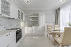 明亮、灰色的现代化厨房，窗边有家用电器和餐桌。阳光。高质量的照片