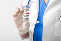 Female doctor with monkeypox vaccine on light background, closeup