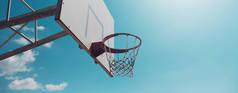 蓝天背景下的篮球篮筐.带有复制空间的全景横幅视图.