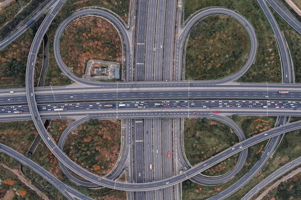大都市多车道公路现代交通交叉口无人驾驶飞机俯瞰的空中景观。高速公路上的交通拥挤。无限速三叶草型高架弯道桥.