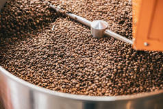 关闭咖啡豆在咖啡烘烤机在一个小制造业。高质量的照片
