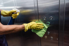 橡胶手套清洗金属电梯中的人的局部视图