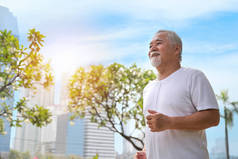 快乐而微笑的亚裔老人在夏天退休后在户外公园里做运动、慢跑或散步，以保持健康。老年人户外保健生活方式概念.