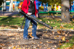 男工摘下花园秋天的草坪。秋天摘下落叶.停车场清洁服务