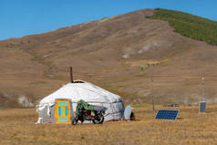 蒙古族农村地区游牧民族的酸奶。在阳光灿烂的日子里，在山岗上搭起一座帐篷，背景是美丽的群山.