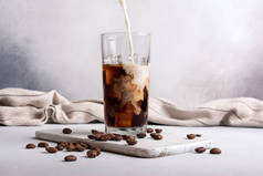 Homemade ice latte. Black coffee with ice and milk or cream in glass for tasty and refreshing break 