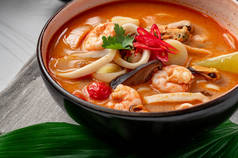 带有虾仁、乌贼、贻贝和蔬菜的辣味亚洲汤汤.亚洲菜。美味和健康的食物。菜单上的照片.