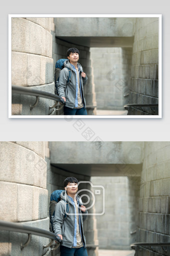 城市背包客倚靠在建筑扶手边中景光晕