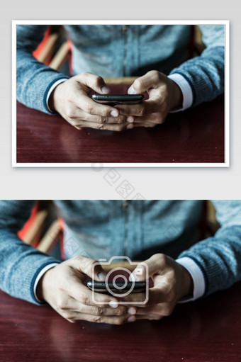 双手玩手机的坐着的人图片