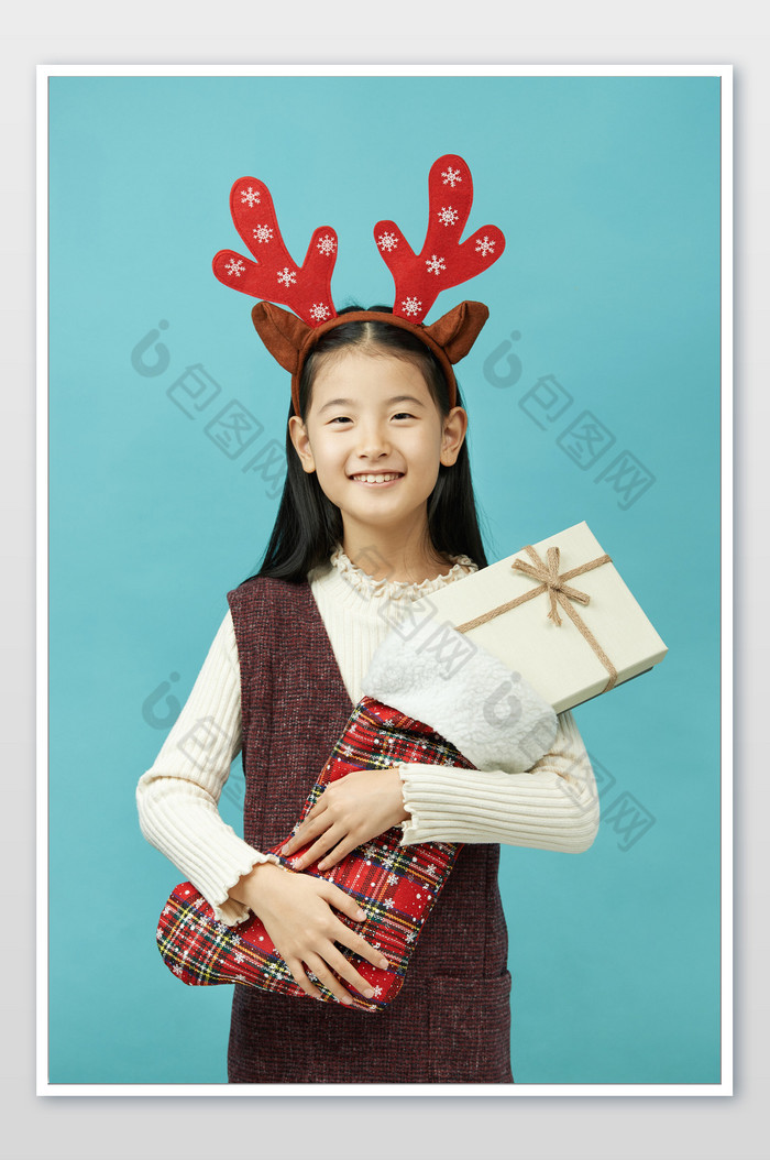 圣诞节抱着圣诞袜和礼物开心的小女孩图片图片