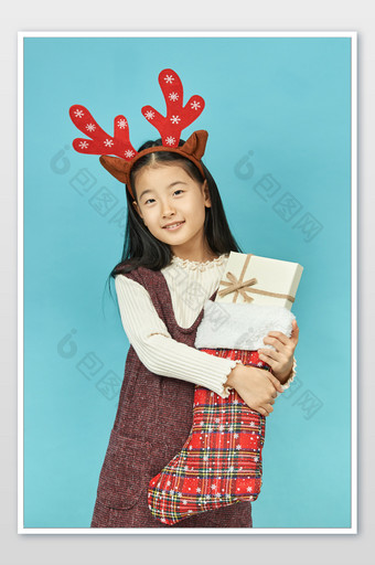 圣诞节抱着圣诞礼物的小女孩图片