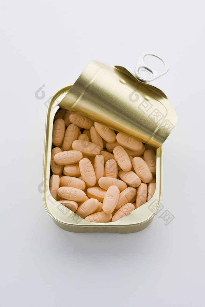 金属罐头里的黄色药片摄影图