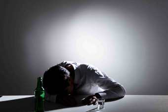 <strong>一个</strong>喝醉的孤独的人趴在桌子上场景图