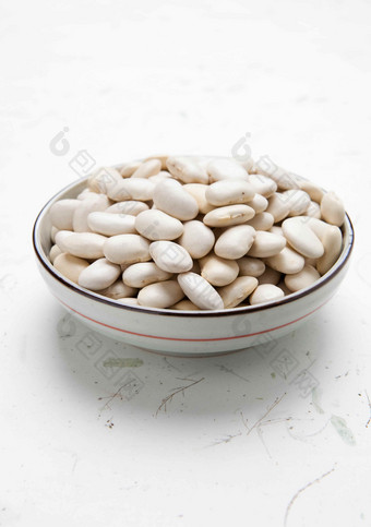白瓷碗里的白色蚕豆摄影图