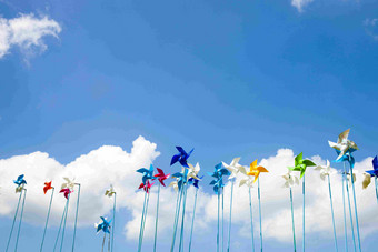 天空下的彩色纸风车展览场景摄影图