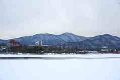 冬季雪山湖边小镇风景摄影图