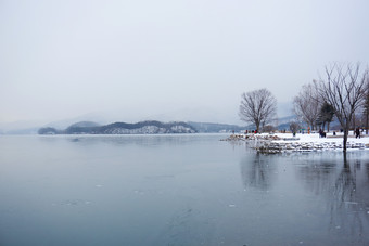 平静的雪天湖面树木风景摄影图