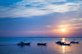 海上日出渔船风景摄影图