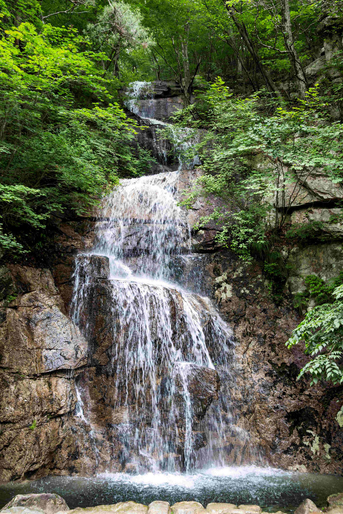山间树林流淌的瀑布自然风景摄影图