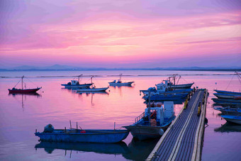 沿海栈桥渔船落日霞光风景摄影图