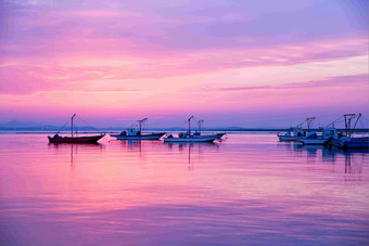 紫色霞光太阳日落渔船海洋风景摄影图
