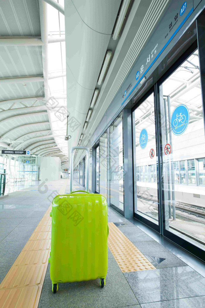 绿色行李箱机场铁路场景摄影图